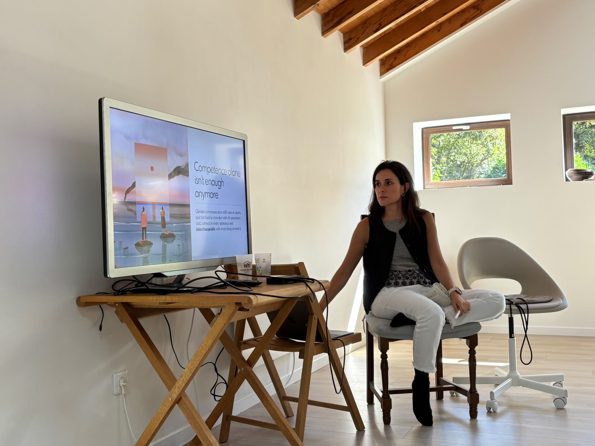 Joana Fonseca presenting the work at the annual offsite, a slide from the deck on the screen beside her.